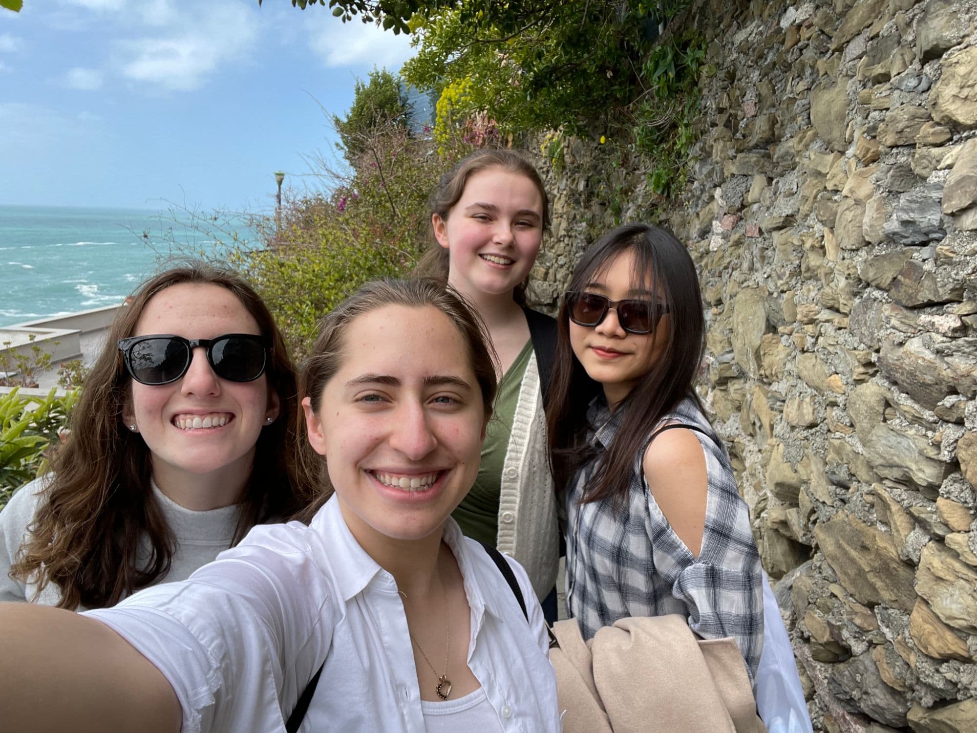 Linh and three friends on a coastal hike in Italy