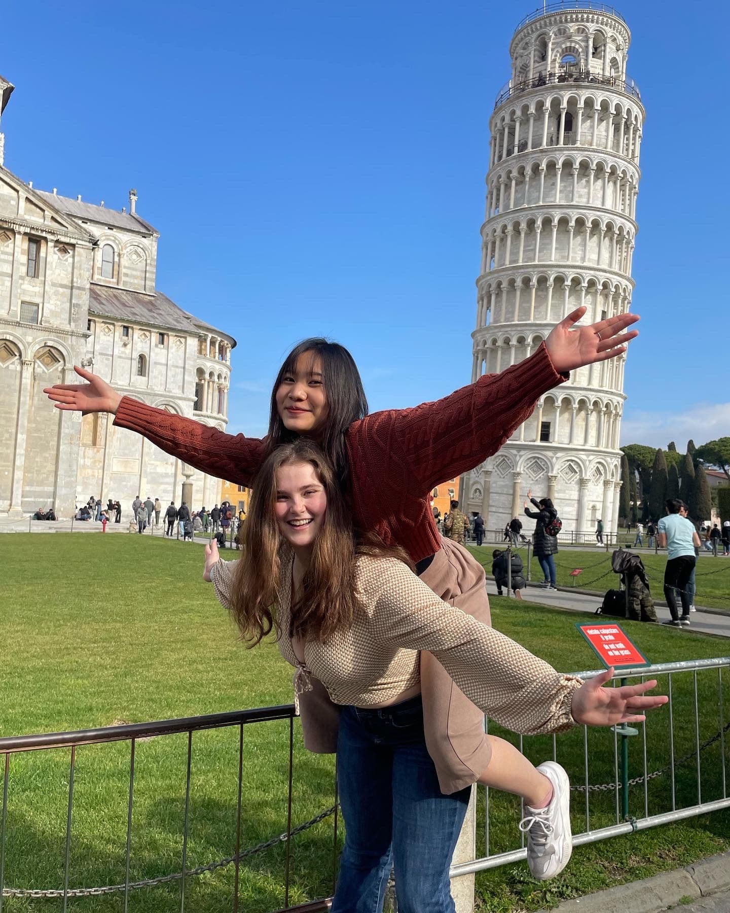 Linh and a friend posing in front of the Leaning Tower of Pisa