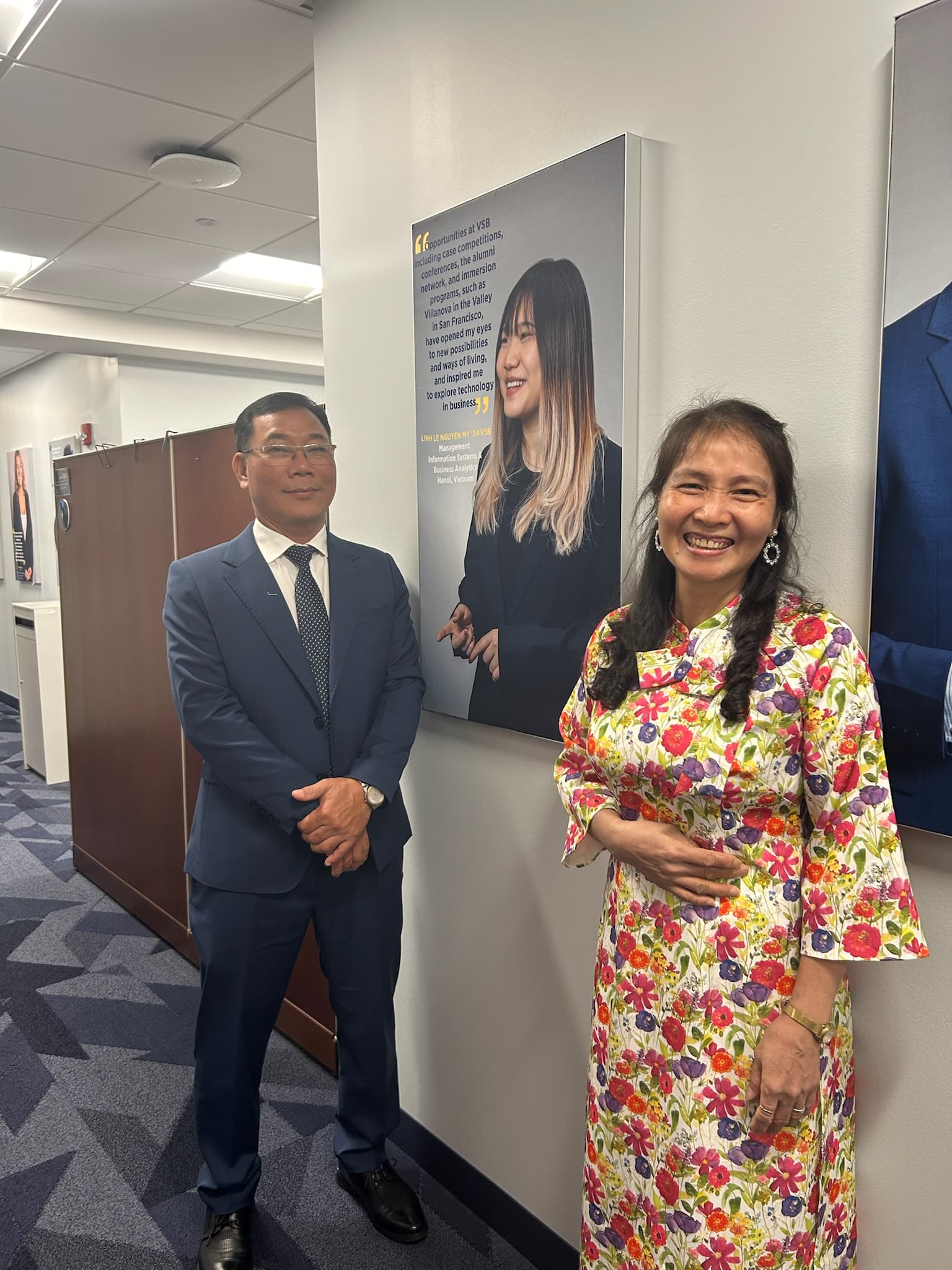 Parents beside Linh's graduation poster