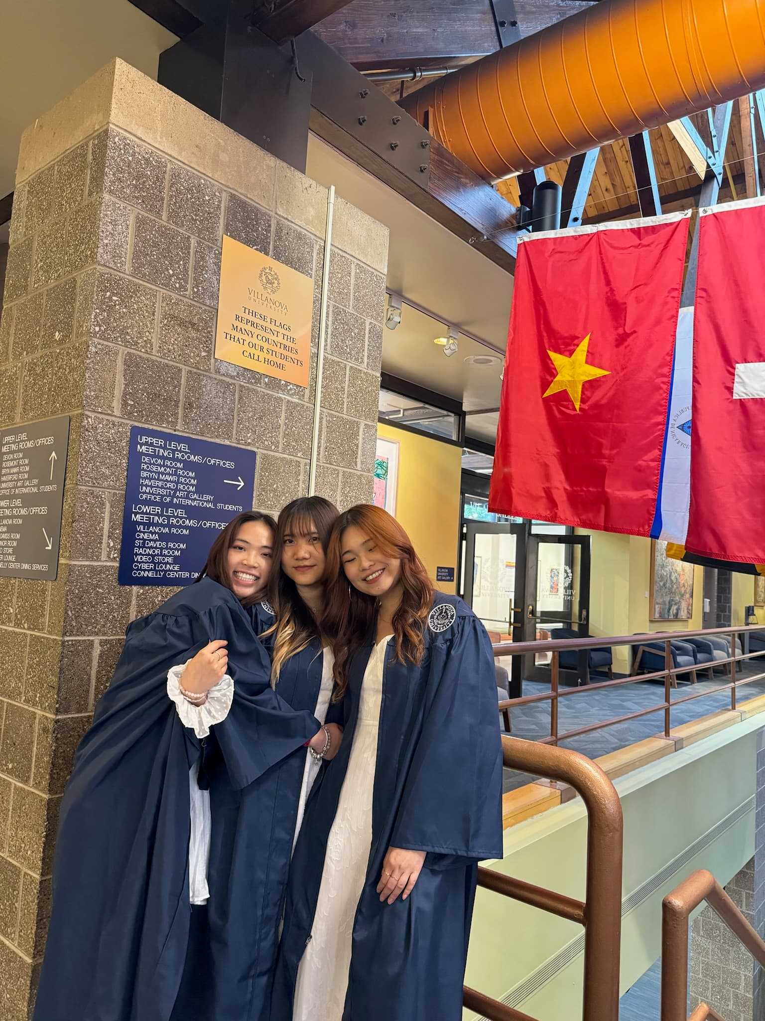 Three Villanova graduates by the Vietnam flag